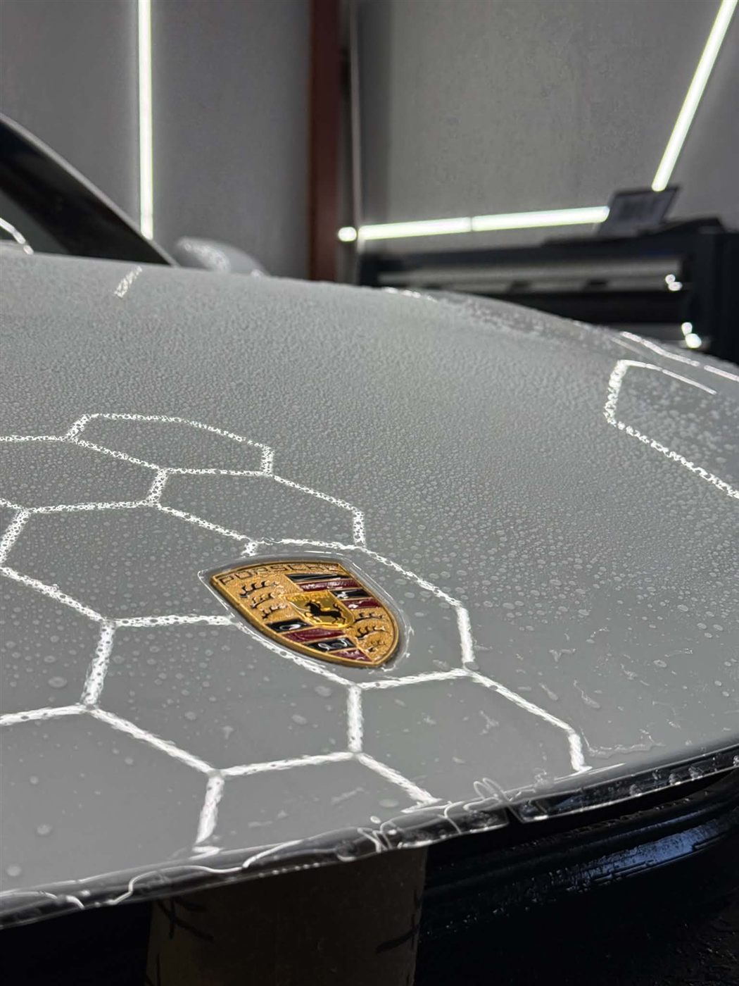 Paint protection film being installed on a Porsche hood
